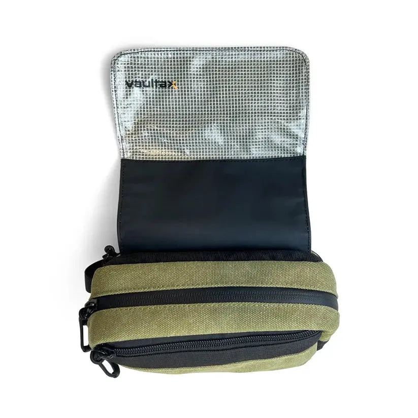 An olive green and black zippered pouch shown open, revealing a black interior and a silver mesh pocket with the 'vaultlax' brand logo printed on it, set against a plain white background.