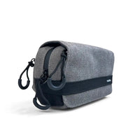 A gray woven fabric pouch with black elastic and zipper trim, shown on a clean white background. A small white 'Vaultlax" label is visible on the side.